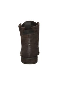 Bottine en cuir marron avec une finition texturée, bout arrondi et languette à l'arrière. Semelle extérieure robuste avec des détails de couture visibles.