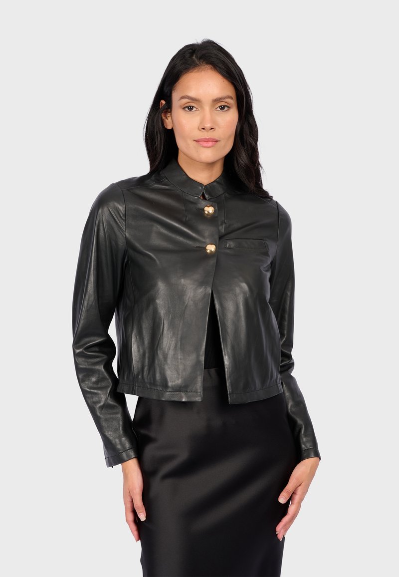 Black leather cropped jacket with a mandarin collar, featuring three gold button closures and a small chest pocket. Smooth texture.