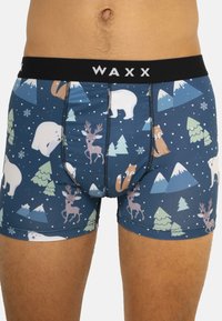 Shorts pour hommes avec un motif bleu foncé mettant en vedette des ours polaires, des rennes et des pins, rehaussés d'une taille noire et d'un logo blanc.