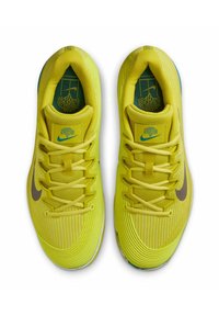 Zapatillas deportivas de un brillante color amarillo, con parte superior de malla texturizada, plantillas verdes y un logo de swoosh marrón. Diseñadas con detalles estampados y una suela duradera.