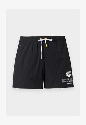 Μαύρο μαγιό σορτς με λευκό κορδόνι και κίτρινα άκρα, με λευκό λογότυπο και κείμενο στο δεξί πόδι.