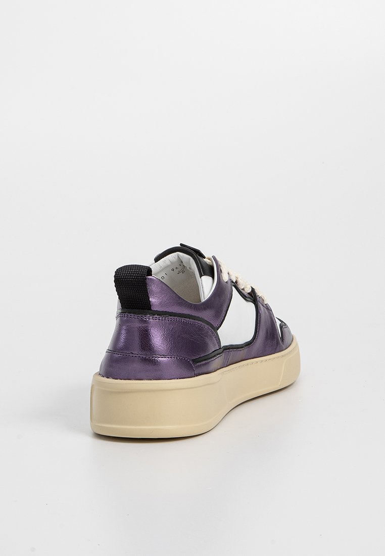 Sneaker metallico viola con accenti bianchi, suola chunky beige, tessuto strutturato e linguetta sul tallone nera a contrasto. I lacci sono beige con una texture intrecciata.