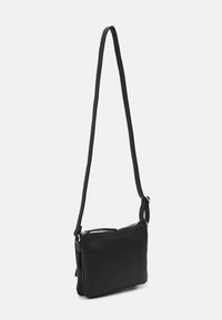 Borsa a tracolla nera in pelle liscia. Forma rettangolare con una singola tracolla regolabile e accessori in metallo dorato. Chiusura con zip.