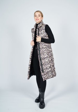 Long, padded vest in beige with black leopard print. Features high collar, front zipper, and side pockets. Worn over a black top and pants.