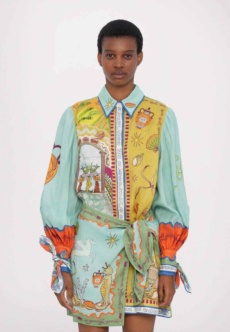 Rochie camasa multicolora cu maneci lungi. Prezintă modele complicate în galben, verde și portocaliu. Guler cu nasturi și talie legată.