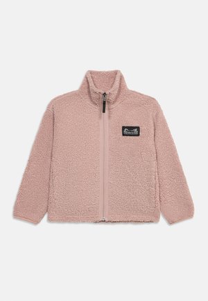 Miękka różowa bluza polarowa na zamek z wysokim kołnierzem oraz czarną prostokątną naszywką z logo na lewej piersi, prezentowana na jasnym tle.