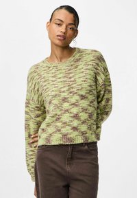 Strickpullover in Hellgrün mit braunem Melange-Muster, Rundhalsausschnitt, langen Ärmeln und lockerer Passform. Kombiniert mit braunen Hosen.