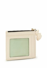 Cartera crema hecha de material texturizado, con un slot para identificación translúcido verde y un pequeño tirador en forma de oso. Cierre de cremallera en la parte superior.