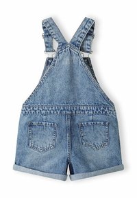 Salopettes en denim bleu clair, avec des bretelles réglables, des ourlets retroussés et deux poches arrière. La texture délavée ajoute un intérêt visuel.
