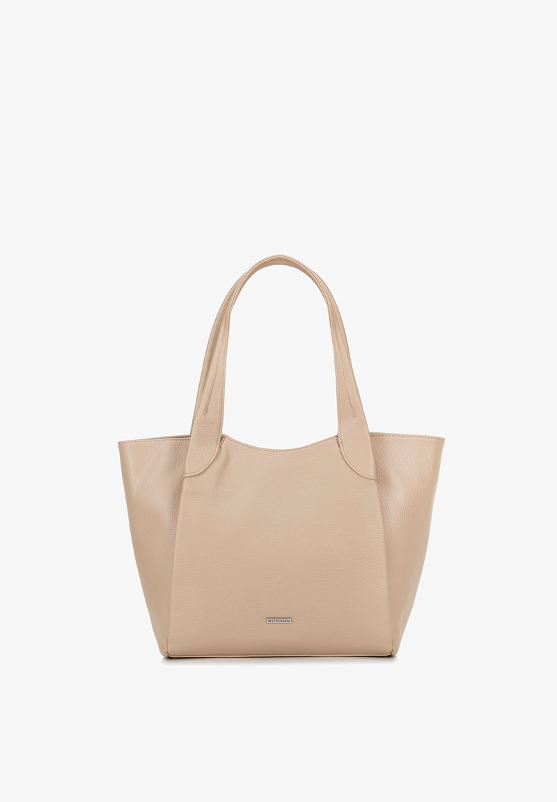 Beige leren draagtas met een gladde textuur, twee schouderriemen en een afgeronde bovenkant. Heeft een metallic logo aan de voorkant.