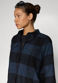 Gestreepte flanellen overhemd in marineblauw en zwart, met knoop sluitingen op de borstzakken, een gekraagde hals en een zachte, gestructureerde stof.