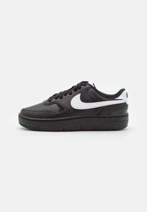 Svarta läder sneakers med vita detaljer, med rund tå, platt sula och klassisk snörningsdesign. På sidan finns en framträdande logotyp.