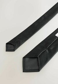 Melnas auduma stūra aizsargu ar taisnstūra formu raksturo gluda tekstūra un redzama šuvuma līnija. Parādīti divi gabali kopā.