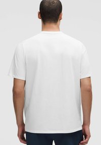 Balts kokvilnas T-krekls ar apaļu kakla izgriezumu, īsām piedurknēm un gludu tekstūru, ar klasisku dizainu un bez redzamām birkām vai rakstiem.