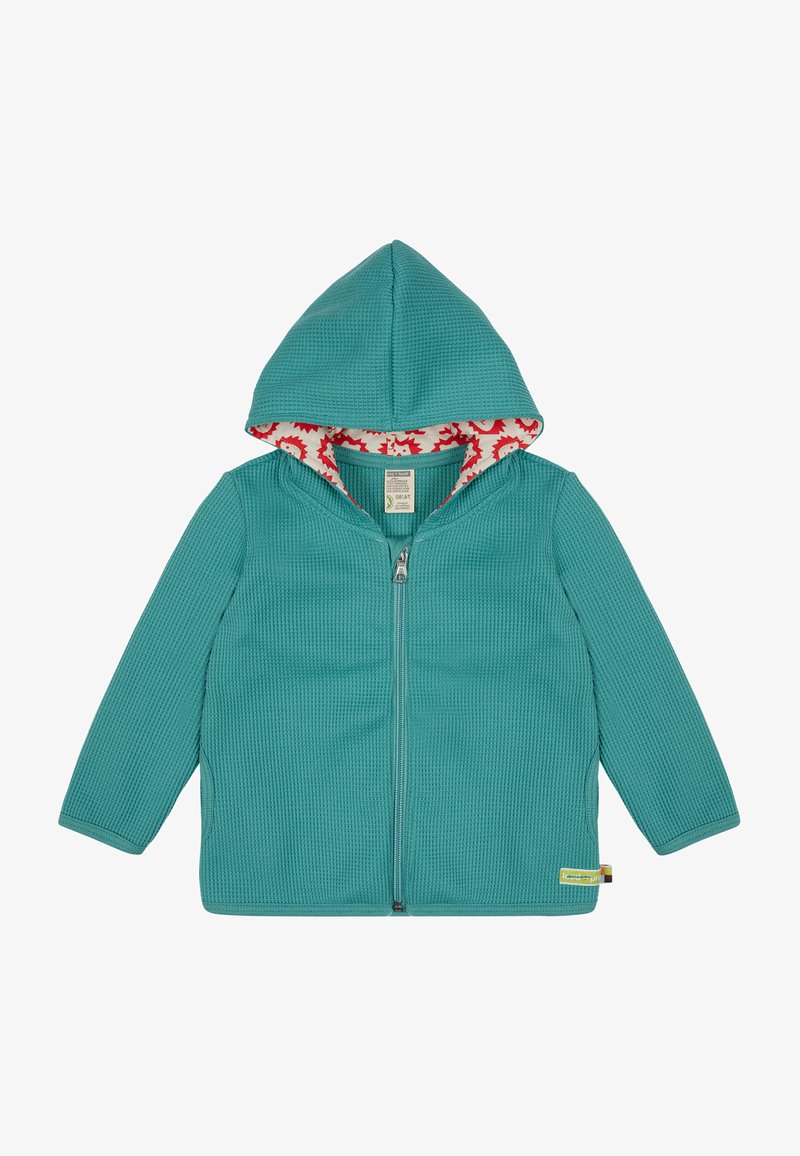 Felpa con zip di colore turchese, caratterizzata da un esterno testurizzato e un rivestimento interno della cappuccio con una fantasia floreale rossa. Include un'etichetta sull'orlo.