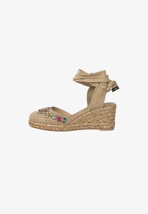 Sandale espadrille compensée beige avec lanière autour de la cheville, semelle en jute tressé, et décorations florales colorées en forme de pierres précieuses sur la zone des orteils.
