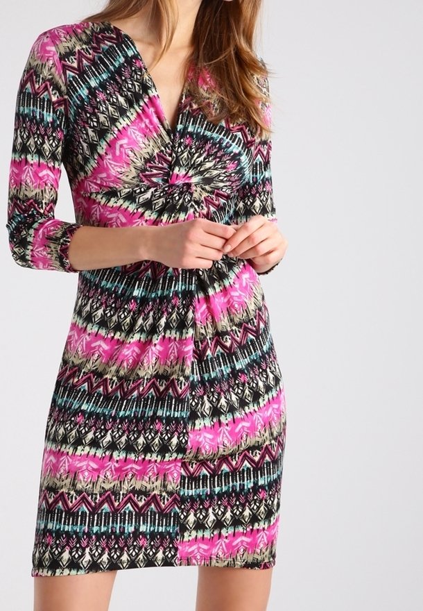 Kurzes Kleid mit tiefem V-Ausschnitt, mehrfarbigen geometrischen und abstrakten Mustern aus überwiegend pinken, schwarzen und türkisfarbenen Stoffen.