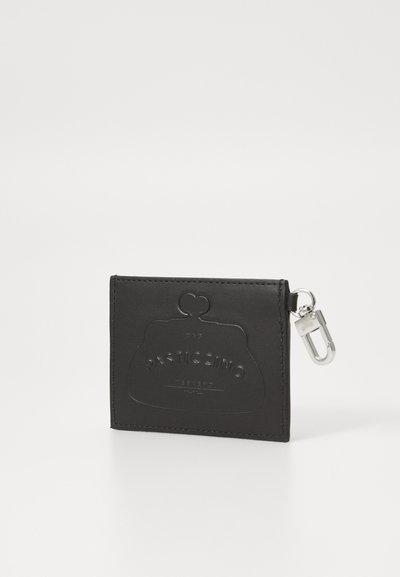 Cartera de piel negra con diseño en relieve, parte superior redondeada, herrajes plateados y clip de mosquetón. Presenta la marca "Pasticcino" en la parte frontal.