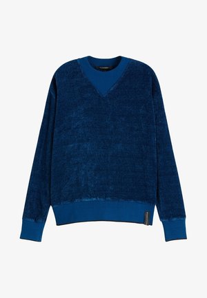 Sudadera azul con cuello en V hecha de tela suave y texturizada. Mangas largas con puños y dobladillo acanalados. Cuenta con una etiqueta de logotipo en el lateral inferior.