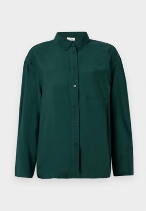 Σκούρο πράσινο, πουκάμισο με μακριά μανίκια και κουμπιά, φτιαγμένο από λείο ύφασμα, με γιακά και μία τσέπη στο στήθος από την αριστερή πλευρά.