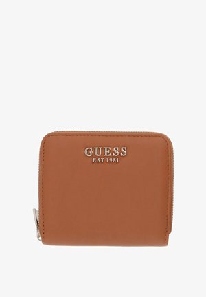 Petit portefeuille en cuir marron avec une fermeture éclair argentée et un logo Guess en métal avec "EST 1981" au centre avant.