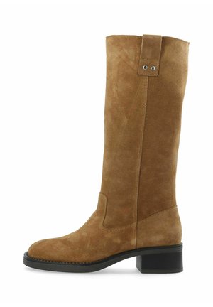 Bota marrón de ante hasta media caña con tacón bloque bajo negro y lengüeta con dos ojetes metálicos en el lado exterior.