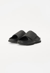 Infradito neri realizzati in morbida pelle scamosciata, con una fascia ampia e un design open toe, dotati di una suola in gomma testurizzata per migliorare la presa.
