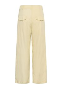 Pantalon beige à jambes larges, taille haute, passants pour ceinture et deux poches à rabat à l'arrière.