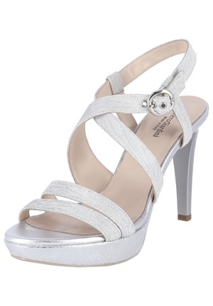 Zilveren sandaal met hoge hak en kruislingse diagonale bandjes, bovenwerk van textiel met structuur en een metalen plateauzool. Voorzien van een ronde gespsluiting.