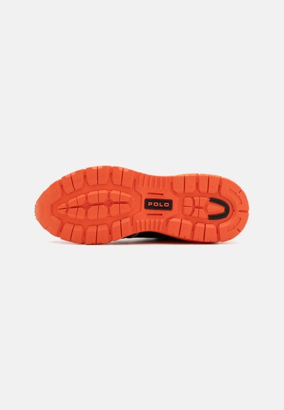 Schwarze Sneaker-Sohle mit ausgeprägten orangen Gummitraktionsmustern, versehen mit einem schwarzen "Polo"-Logo. Strukturiert für Grip und Langlebigkeit.