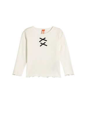 Haut blanc à manches longues avec un col rond et un ourlet festonné. Présente deux accents en ruban noir formant un motif en "X" sur le devant.