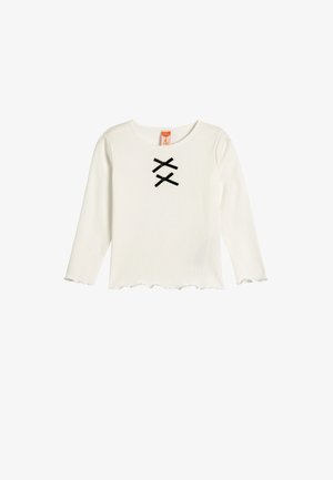 White long-sleeve top with a round neckline and scalloped hem. Features two black ribbon accents forming an "X" pattern on the front.