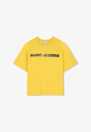 Żółta koszulka z krótkim rękawem z czarno-białym kropkowanym napisem "MARC JACOBS" na środku klatki piersiowej oraz okrągłym dekoltem.