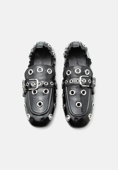 Μαύρα δερμάτινα μοκασίνια με ασημένιες τρύπες και αγκράφες στην κορυφή, με ελαστικό συγκέντρωμα γύρω από τη φτέρνα για άνετη εφαρμογή.