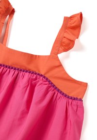 Buntes Kleid mit rüschierten orangen Trägern, einem gerafften, leuchtend pinken Oberteil und einem lila Pom-Pom-Besatz entlang des Taillenbundes. Aus Baumwollmaterial.