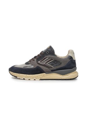 Lage sneaker met zwart, grijs en beige suède en stoffen bovenwerk, beige gevlekte zool en donkerbruine veters, gezien vanaf de linkerkant.