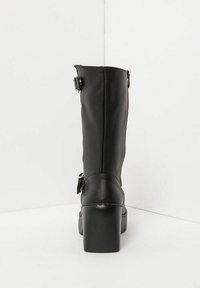 Czarne ankle boot z materiału skóropodobnego na wysokim, blokowym obcasie, z zapięciem na zamek błyskawiczny oraz regulowanym detalem w postaci klamry po boku.