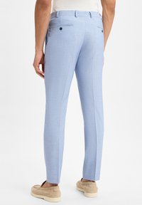 Hellblau maßgeschneiderte Hose aus einem strukturierten Stoff, mit schmaler Passform, zwei hinteren Taschen mit Knöpfen und einem gebügelten Falten entlang der Vorderseite.