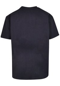 Svart kortermet t-skjorte laget av bomull. Har rund hals og en jevn tekstur uten synlige mønstre eller design.