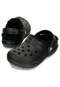 Les sabots noirs Crocs présentent un talon fermé, une doublure douillette, de grands trous de ventilation sur la partie supérieure, et une semelle texturée et durable.