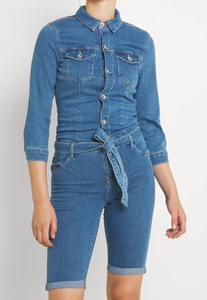 Niebieski kombinezon dżinsowy z przodem na guziki, kołnierzem, długimi rękawami, kieszeniami na piersiach oraz wiązanym paskiem w talii, z podwiniętymi mankietami.