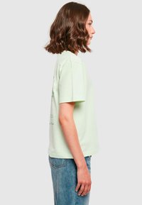 Lys grøn bomulds t-shirt med korte ærmer. Har en rund halsudskæring og en afslappet pasform. Minimalistisk design uden synlige mønstre eller detaljer.