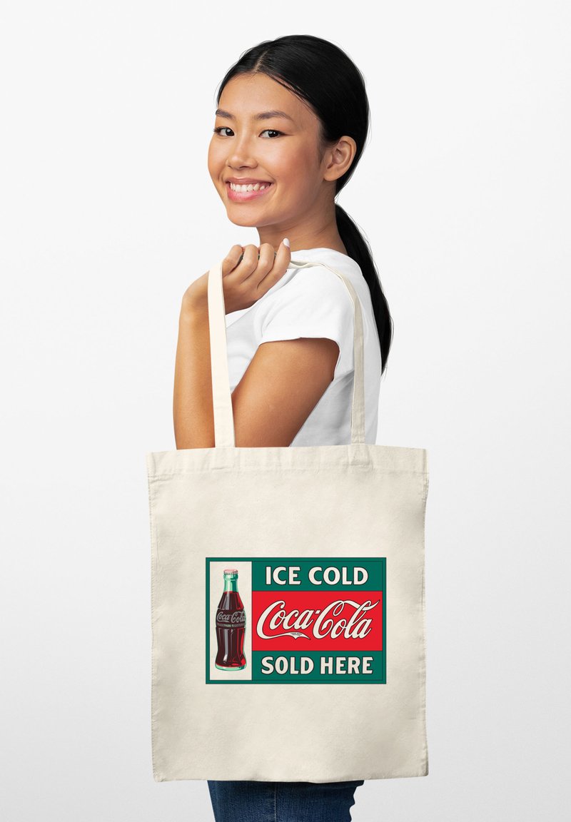 Canvas tote bag in natuurlijke kleur met een retro Coca-Cola advertentie, voorzien van een groene rand en een helderrode achtergrond.