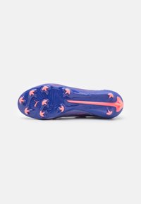 Crampon de football avec un design violet et rose, présentant une semelle texturée et des pointes de traction rose. La forme est élancée pour la performance.