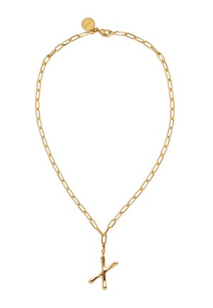 Collar de cadena de oro con eslabones alargados y un colgante irregular en forma de cruz colgando del centro, cierre y etiqueta redonda en la parte superior.
