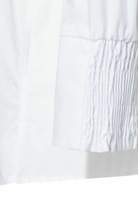 Witte shirt mouw met een gathered elastische detail en een gladde stofstructuur. De manchet is lichtjes uitlopend voor een verstelbare pasvorm.