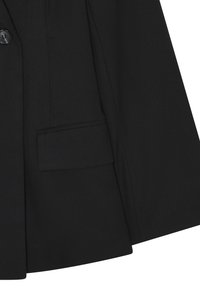 Zwarte op maat gemaakte blazer met twee knopen, een notch revers en een enkele opgestikte zak; gemaakt van een gestructureerde stof met een gladde afwerking.