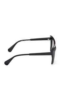 Occhiali da sole neri con montatura rettangolare visti di lato, che mostrano le aste e le estremità curve su uno sfondo bianco.