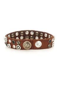 Bracciale in suede marrone con borchie in metallo argentato e accenti decorativi, tra cui un ciondolo a forma di logo rotondo e vari elementi metallici di forme diverse.