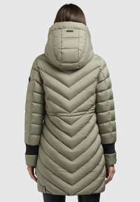 Vadderad lång jacka i ljus olivgrön, med chevron-quilting, huva och svarta ärmavslut. Slät, vattenavvisande tyg.